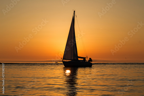 yacht with a sail at sunset in the sea