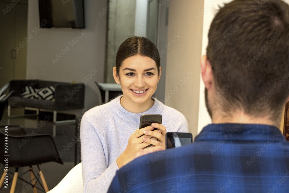 boy and girl students, in the hands of a smartphone, smiling boy and girl students, in the hands of a smartphone, smiling