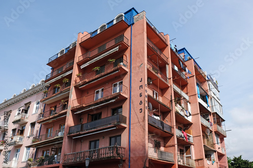 An ordinary residential building close to the center of the city. Red buildings on the streets of Batumi.