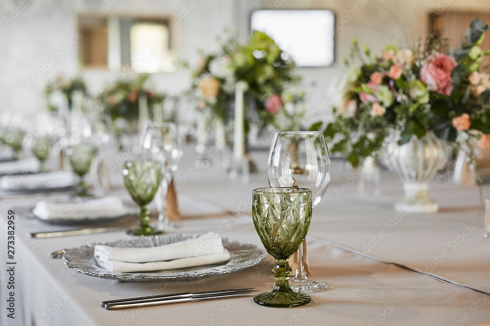 Table served with glasses, plate, forks and knives. Served festive table ready for guests. Luxury wedding table