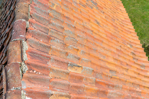 A red ceramic roof tile placed on an old building  photos taken up close.