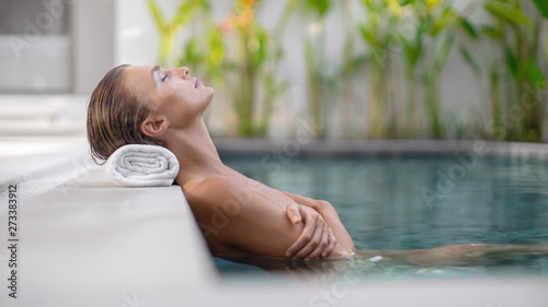 Beautiful girl relaxes around the pool. Spa