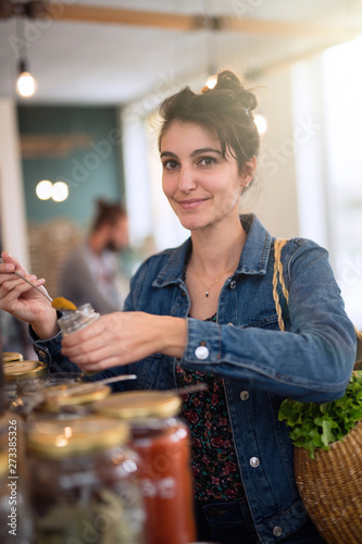 Beautiful young woman shopping in a bulk food store