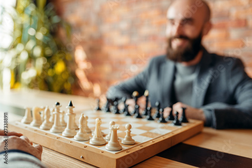 Male chess players, focus on board with figures