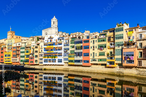 Colorful yellow and orange houses reflected in water, Girona