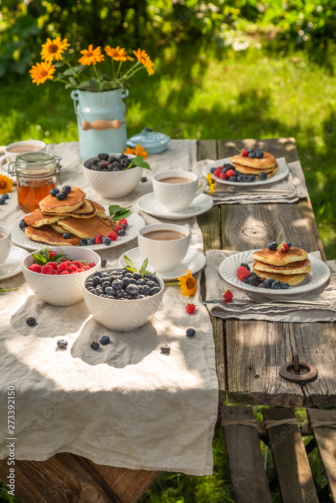Pancakes with raspberries and blueberries in summer garden