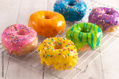 A Batch of Rainbow Donuts on a White Wood Table photo