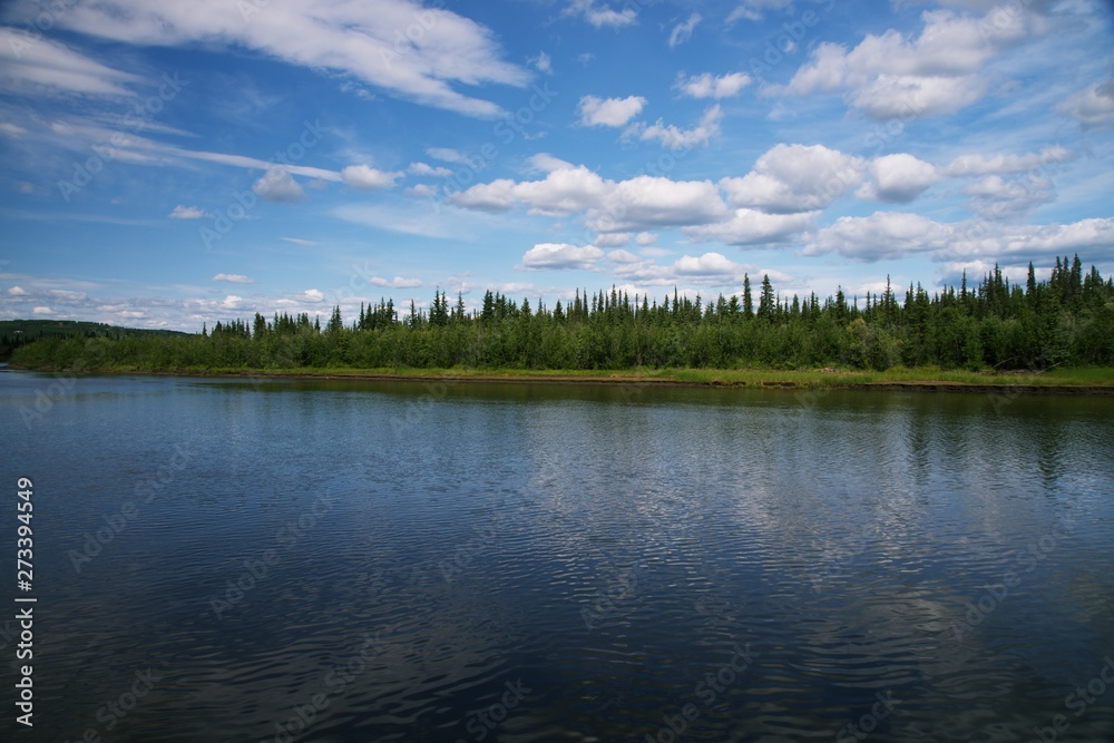 Reflection of blue shy with clouds in River, with forrest between river and sky Reflection of blue shy with clouds in River, with forrest between river and sky