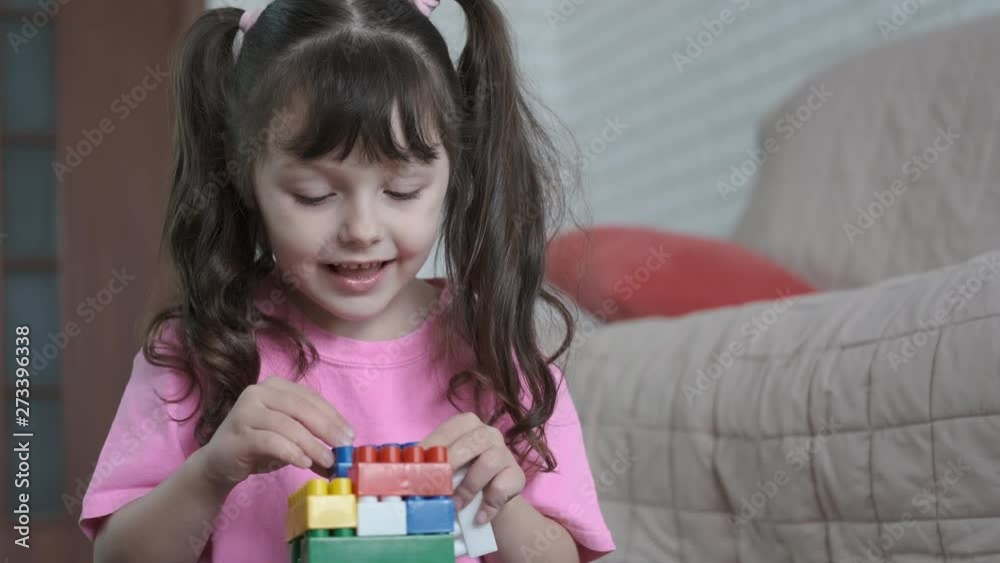 Happy kid plays with the constructor. Cute little girl assembles constructor. Happy kid plays with the constructor. Cute little girl assembles constructor.