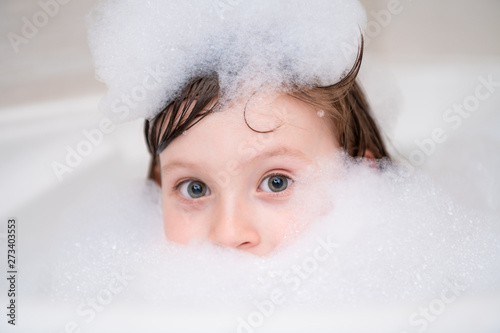 Fototapeta little girl in bath playing with foam