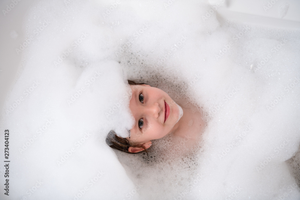top view of little girl in bath playing with foam top view of little girl in bath playing with foam