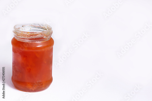 Glass jar of jam on a white background