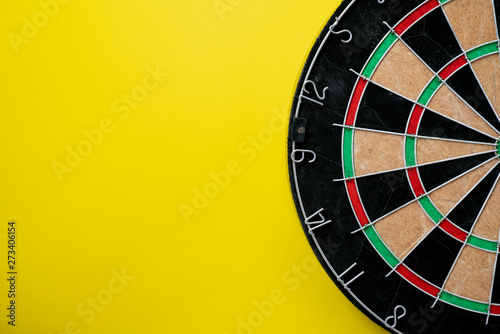 target dart board on the table yellow background, center point, head to target marketing and business success concept