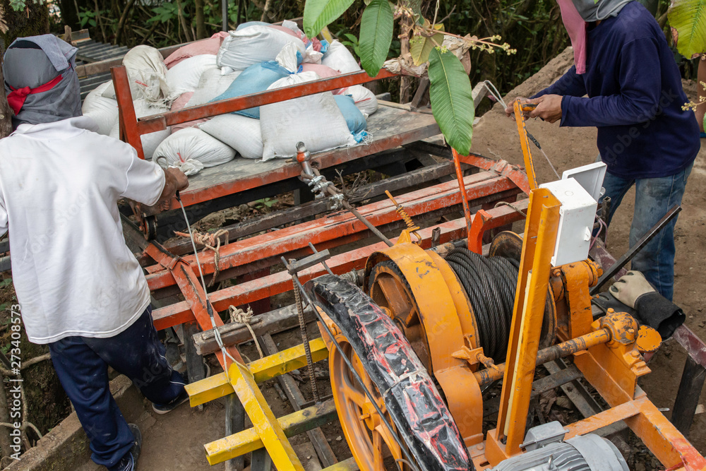 Construction workers are using electric winches to transport sandbags. Construction workers are using electric winches to transport sandbags.