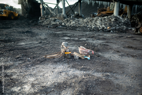 Miner equipment, flashlight battery and helmet, dumped on the ground