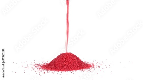 Red sand pouring and making a conical pile on a solid white background