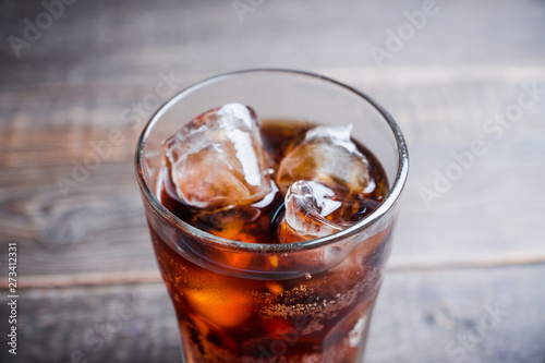 Refreshing cold cherry cola on the wooden background. Selective focus.
