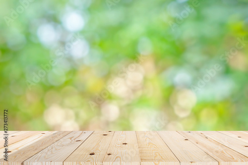 Empty wooden table top and green bokeh
