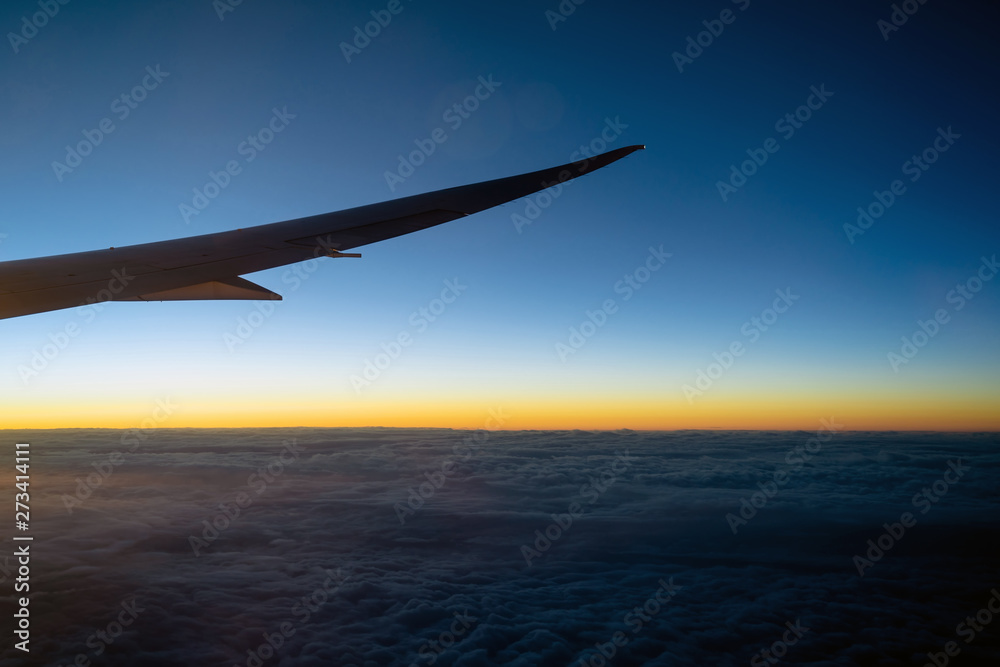 Scene of Airplane wing over the cloud and fantastic sky at sunrise time when flying above the land, Nature and travel concept Scene of Airplane wing over the cloud and fantastic sky at sunrise time when flying above the land, Nature and travel concept