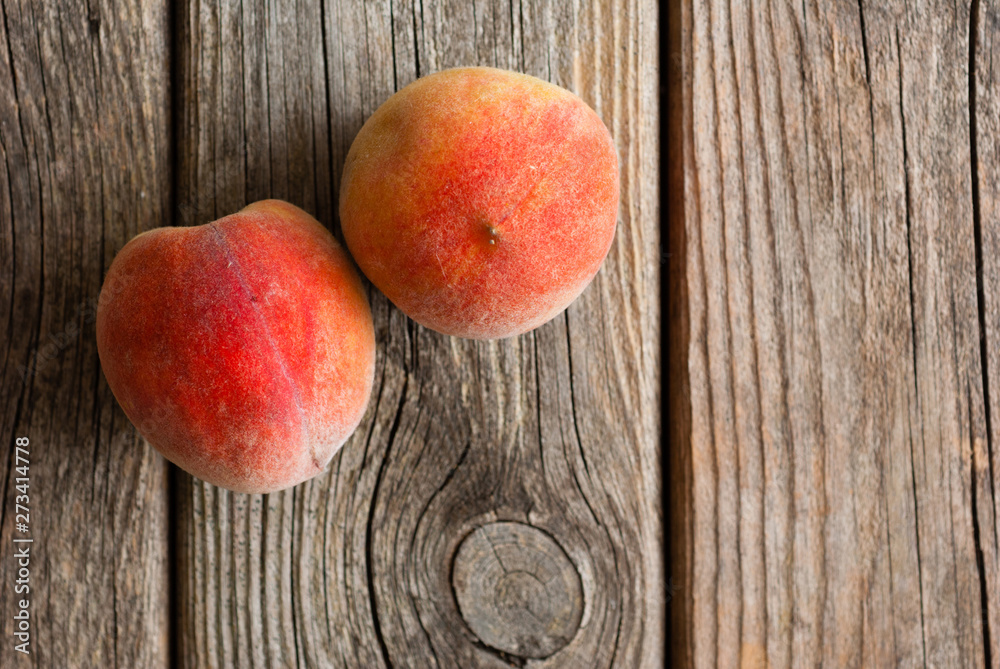two peach fruits on old weathered wooden table background two peach fruits on old weathered wooden table background