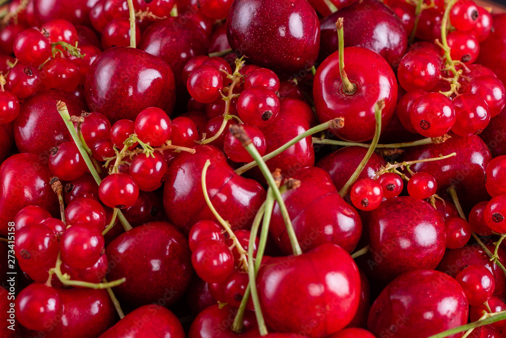 Sweet fresh organic cherry background close-up. Cherry in the plate with leaves on a dark background Sweet fresh organic cherry background close-up. Cherry in the plate with leaves on a dark background