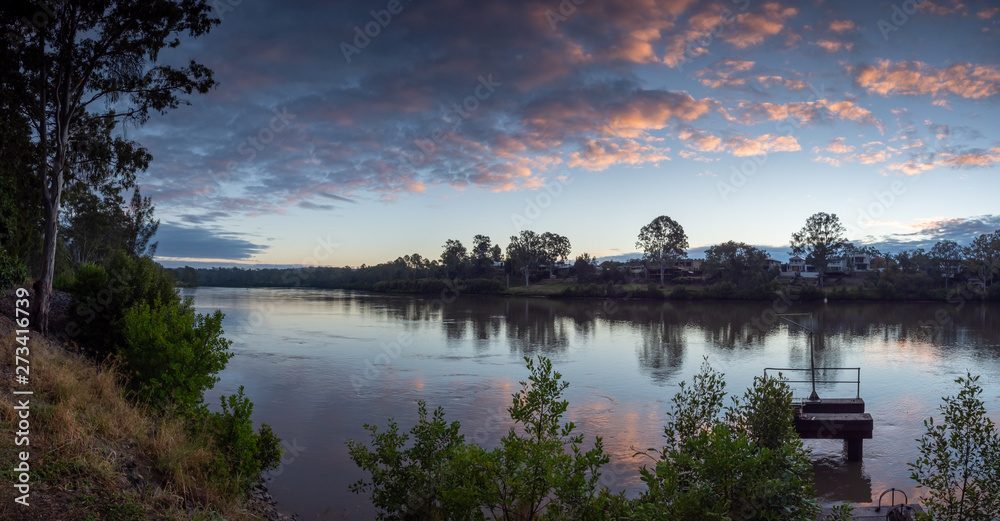 Obraz premium River Sunrise with Dramatic Sky and Reflections
