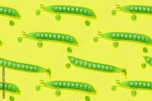 Pattern fresh green pea pods and peas on the yellow background