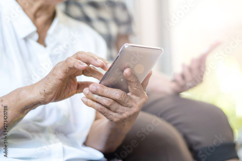 Happy elderly senior people society lifestyle technology concept. Ageing Asia women using tablet smartphone or mobile phone share social media together in wellbeing county home.