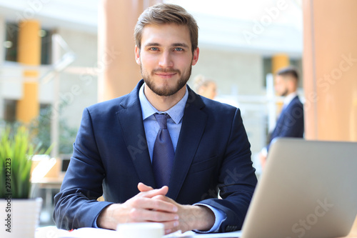 Portrait of young man sitting at his desk in the office.