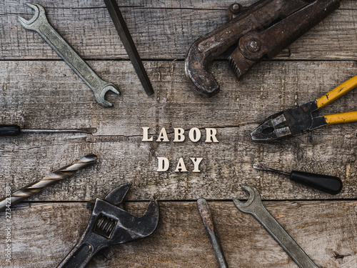 LABOR DAY. Hand tools and wooden letters lying on the table. Top view, close-up. Preparing for the celebration. Congratulations to loved ones, family, relatives, friends and colleagues