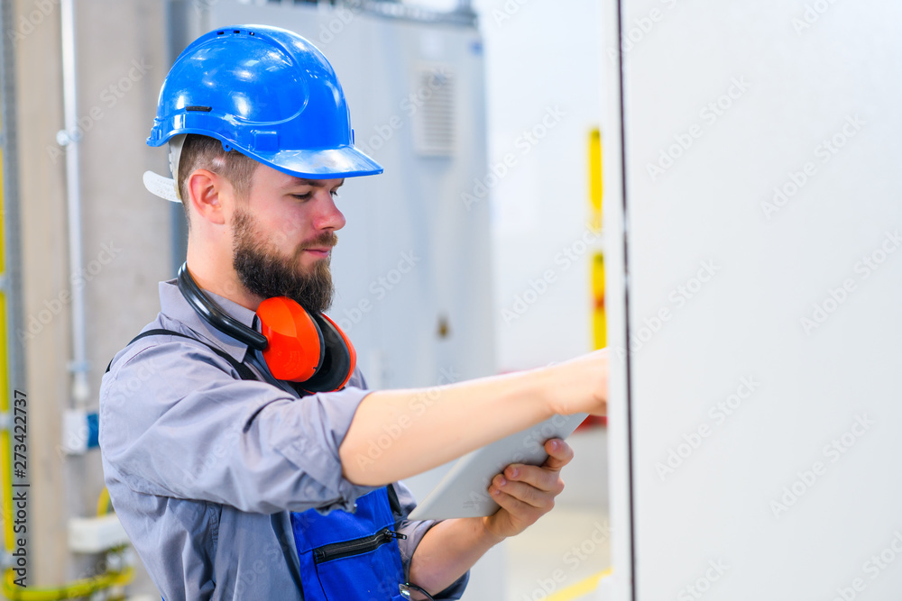 worker with helmet ,ear protector and tablet computer worker with helmet ,ear protector and tablet computer