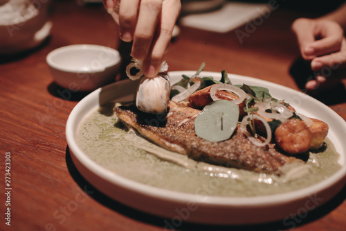 Plate with tasty cooked seabass fish and vegetables on table 