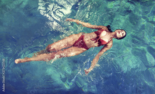Sensual woman relaxing in the tropical, luxurious pool © konradbak