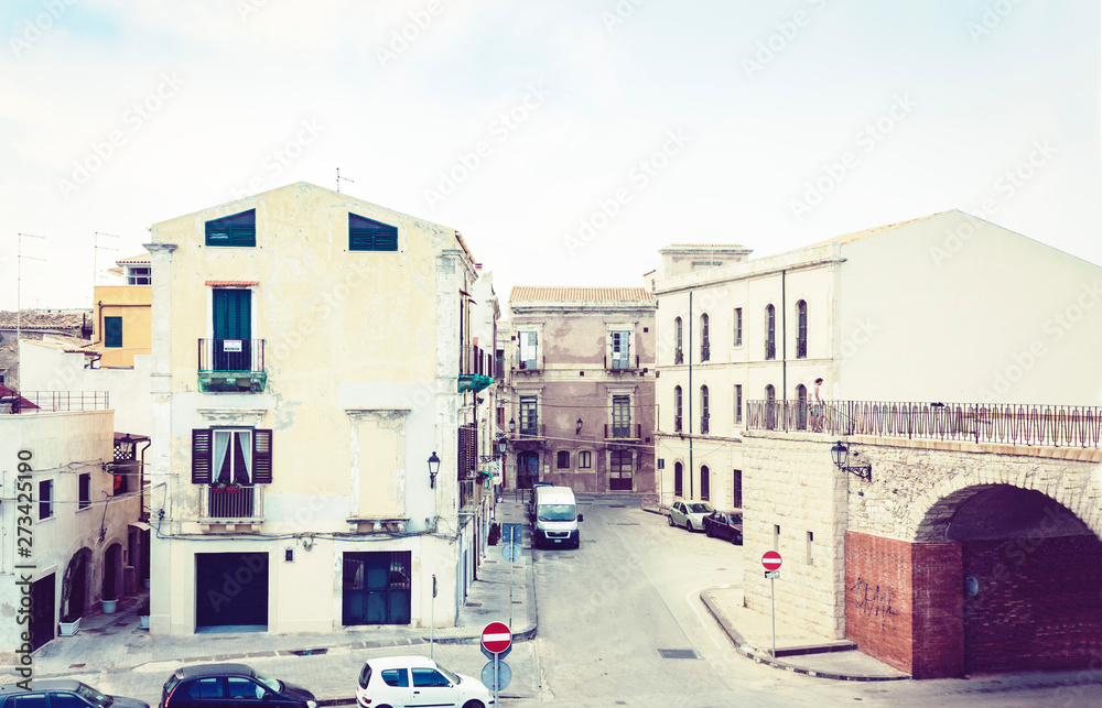 View of old street, facades of ancient buildings in seafront of Ortygia (Ortigia) Island, Syracuse (Siracusa), Sicily, Italy.