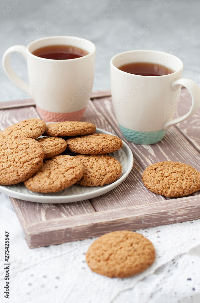 A tasty snack: two cups of tea and a plate of cookies. A tasty snack: two cups of tea and a plate of cookies.