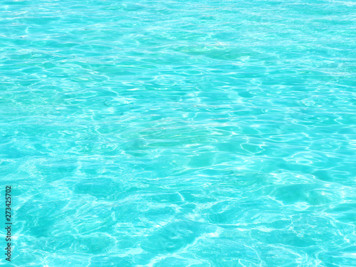 Background and texture of turquoise wavy water in the pool in the sun...