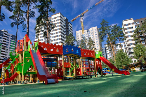 Photography multi-colored playground for children in the park between high-rise buildings