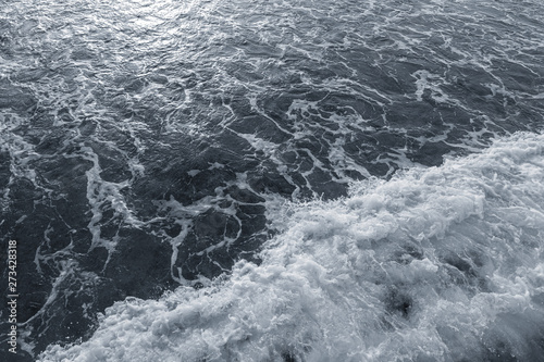 Dark water of stormy sea and white foam. Horizontal color photography.