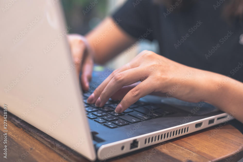 Close up. Business woman black shirts using white laptop hands typing on the notebook keyboard on classic table at cafe. Work space. Programmer concept. Close up. Business woman black shirts using white laptop hands typing on the notebook keyboard on classic table at cafe. Work space. Programmer concept.