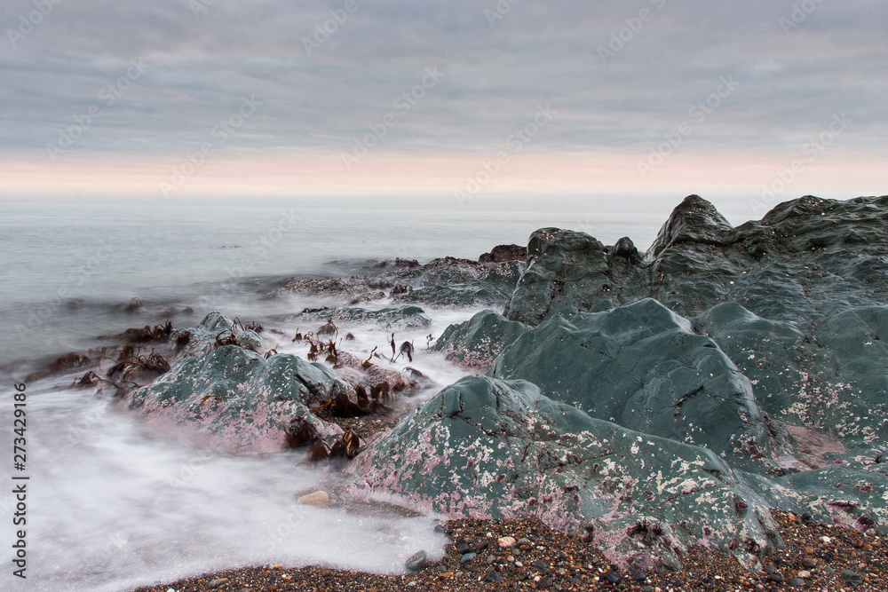 Obraz premium A beautiful scenery of wave splashing at the sunrise.