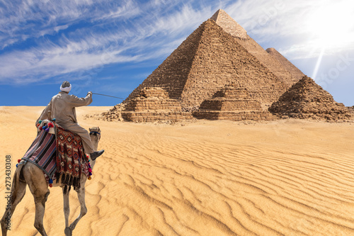 A bedouin of Giza desert in front of the Great Pyramids  Egypt