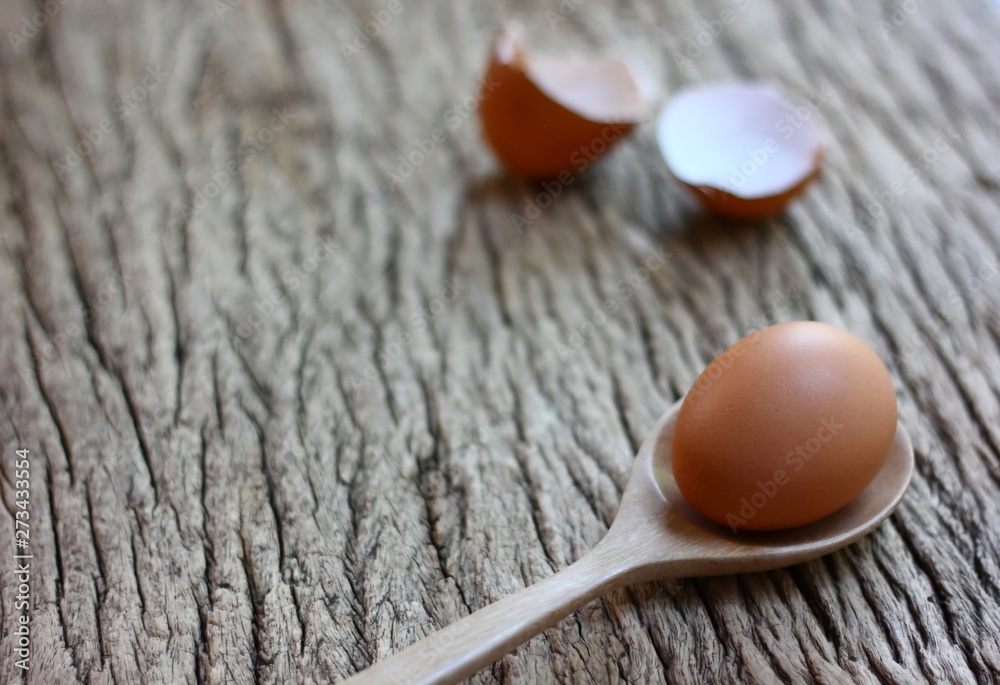 chicken egg with wood spoon on retor wood table background. chicken egg with wood spoon on retor wood table background.