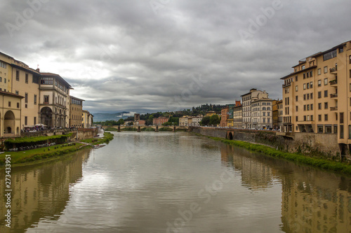 Italy, Florence, the capital of Tuscany. View from the Ponte Vecchio on the Arno River and the surrounding urban areas. Pre-storm May sky.