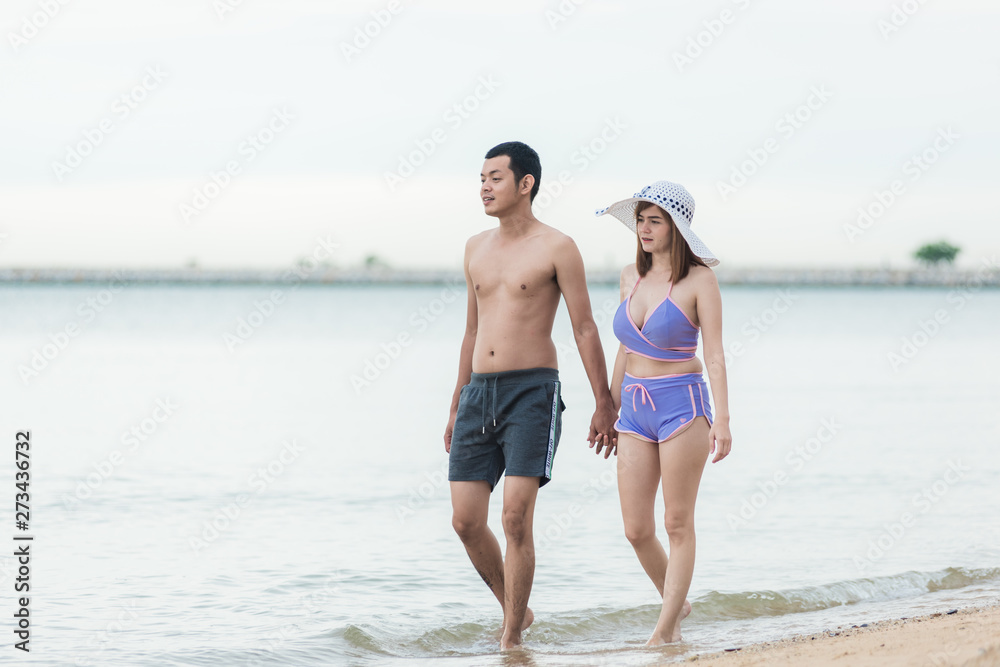 Happy young couple romantic lifestyle walking on tropical beach travel relaxation