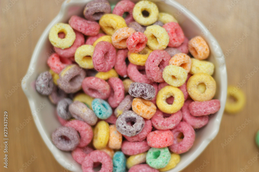 multicolored cereals in a white bowl on wood background multicolored cereals in a white bowl on wood background