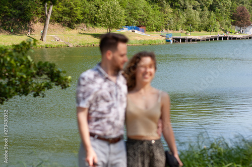 Young couple want to take a photo of them by a tourist, but inexpert and the picture is out of focus and decomposed