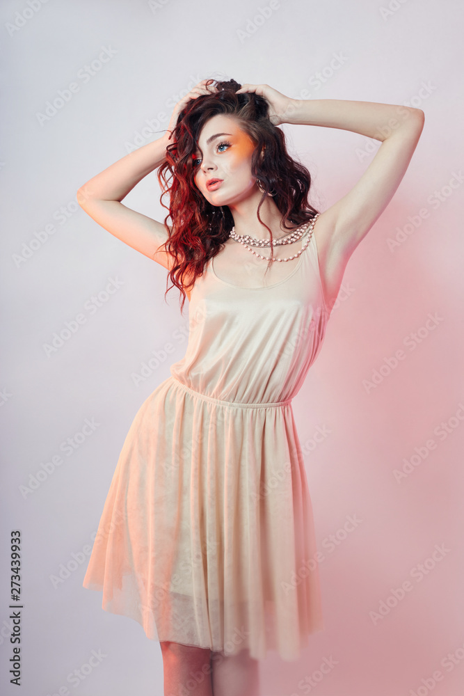Fashion woman stands, bright red makeup, curly hair and light summer dress. Girl perfect art makeup colored background Fashion woman stands, bright red makeup, curly hair and light summer dress. Girl perfect art makeup colored background