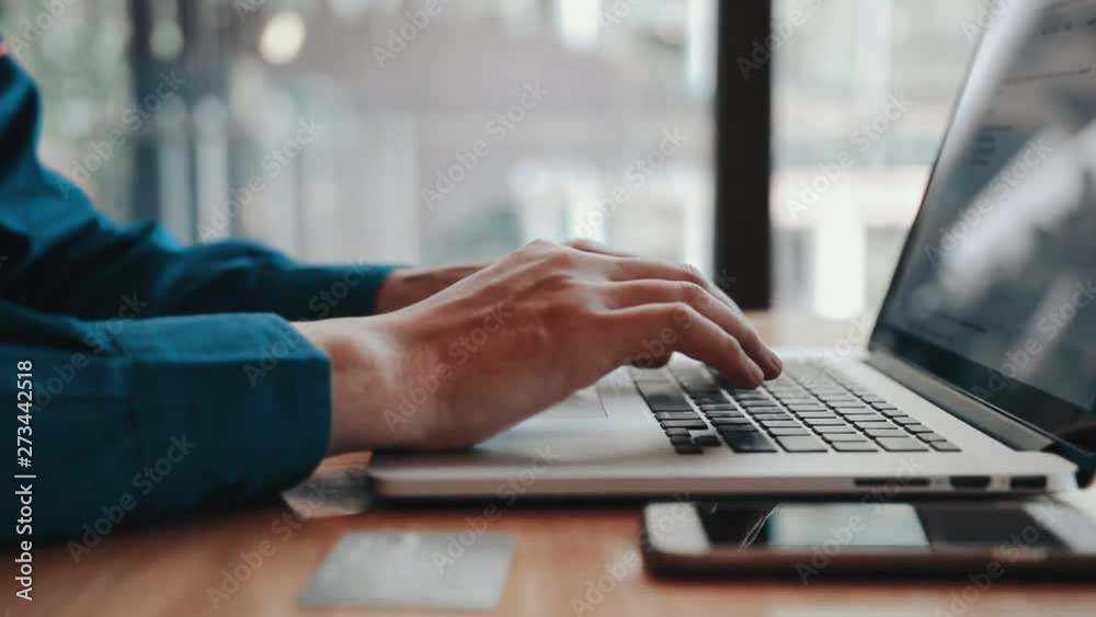 Man using finger typing on keyboard laptop computer for shopping online on table.