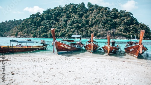 Long Tail Boats on Bright Blue Turquoise Water on an Island In Thailand, Off Koh Lipe in Tarutao - Waiting for Snorkelling People