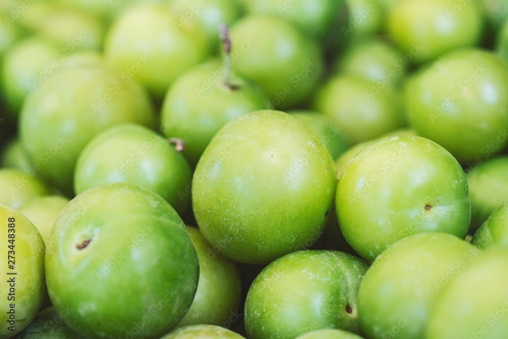 Green plums close-up. Fresh plums (cherry plums) background pattern close up, top view Green plums close-up. Fresh plums (cherry plums) background pattern close up, top view